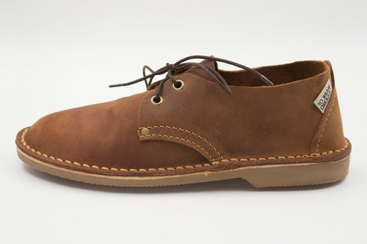 Side view of South African handmade vellie in medium brown leather showing traditional stitching detail