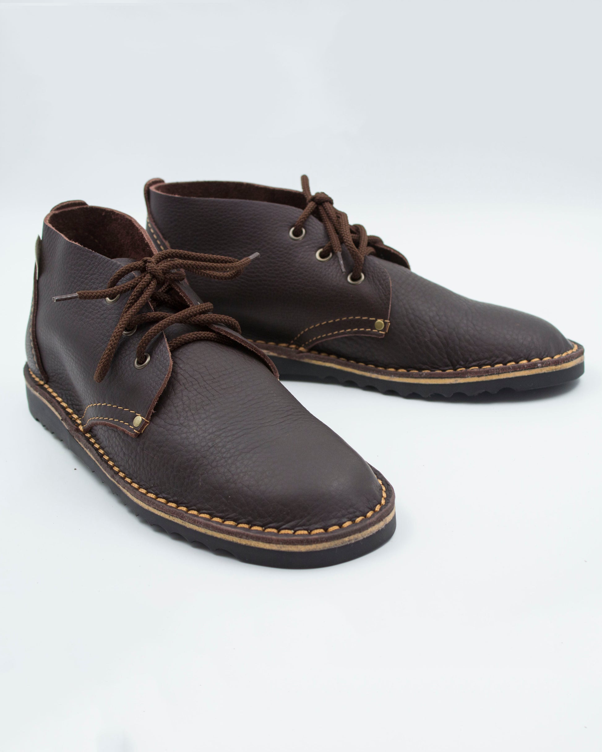 Handmade high-cut veldskoen in dark brown full-grain leather with brass eyelets and black sole