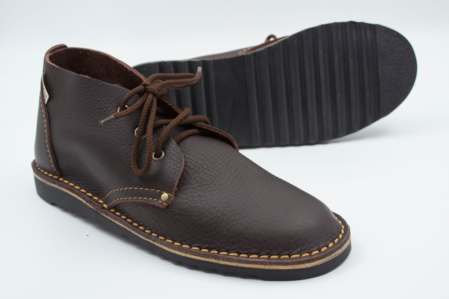High-cut veldskoen dark brown leather with durable ridged black sole showing traction pattern