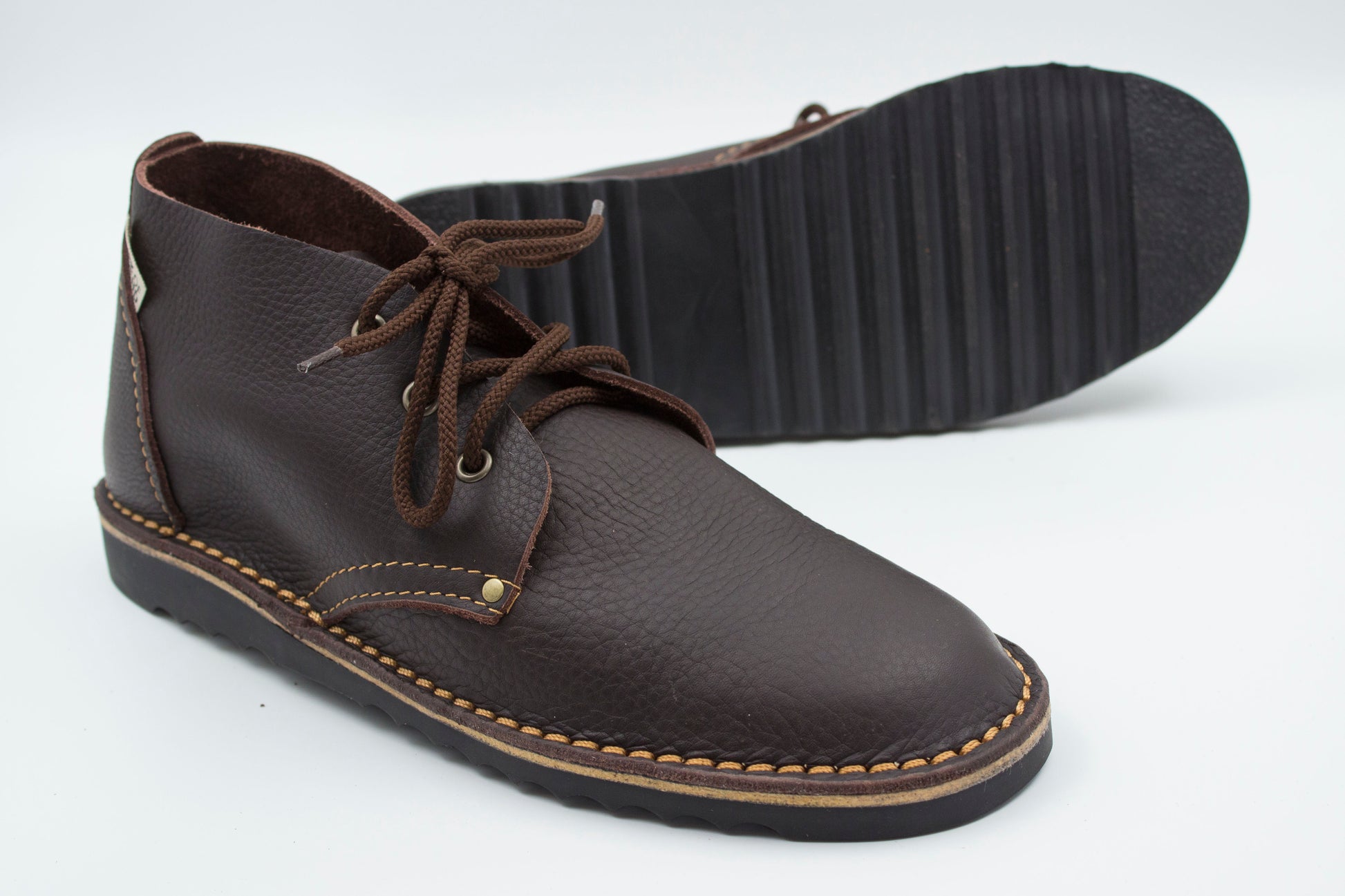 High-cut veldskoen dark brown leather with durable ridged black sole showing traction pattern