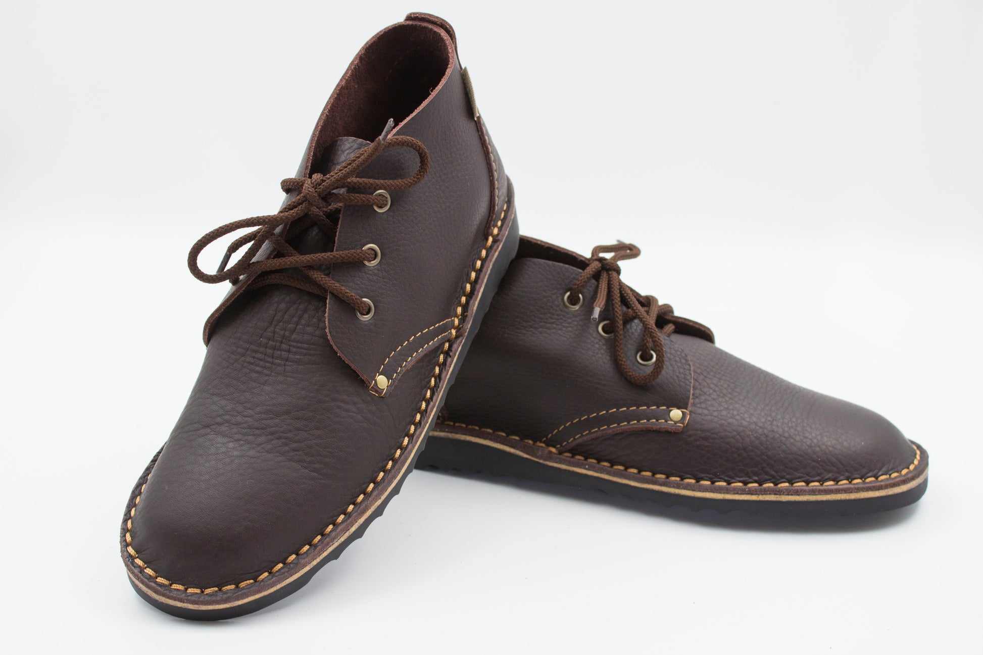 Handmade high-cut veldskoen in dark brown full-grain leather with brass eyelets and black sole