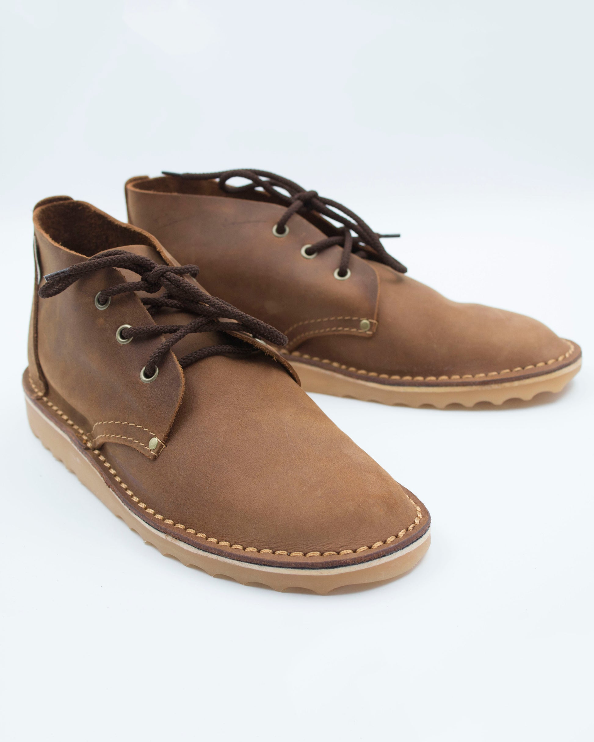 Handmade high-cut veldskoen in medium brown full-grain leather with brass eyelets and crepe sole