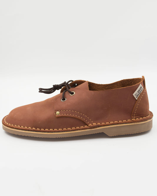 Side view of South African handmade vellie in medium brown leather showing traditional stitching detail