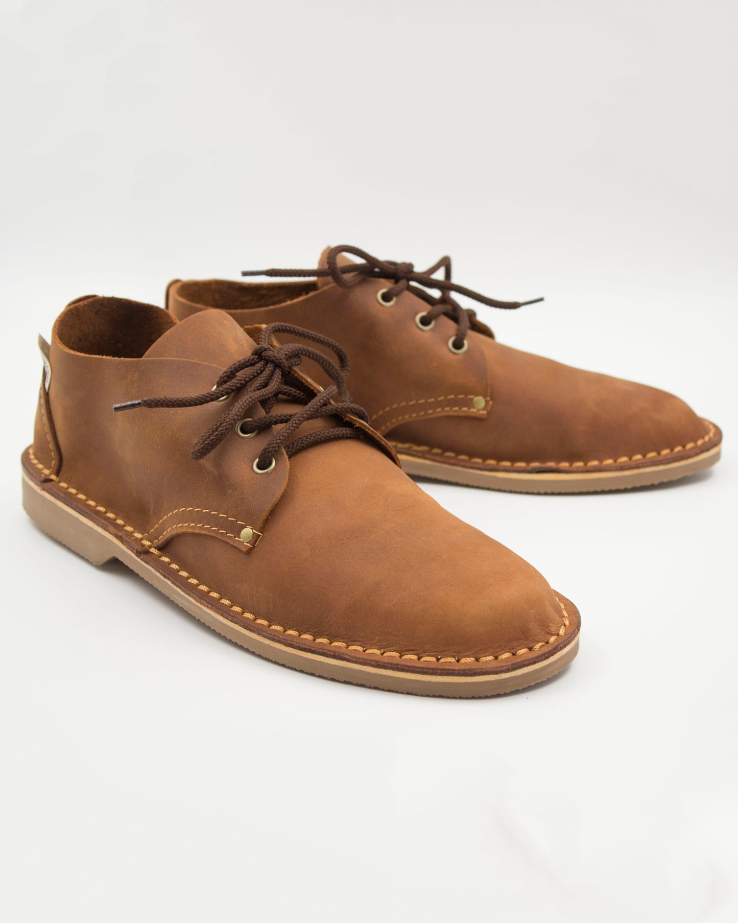 Handmade low-cut veldskoen in medium brown full-grain leather with brass eyelets and crepe sole