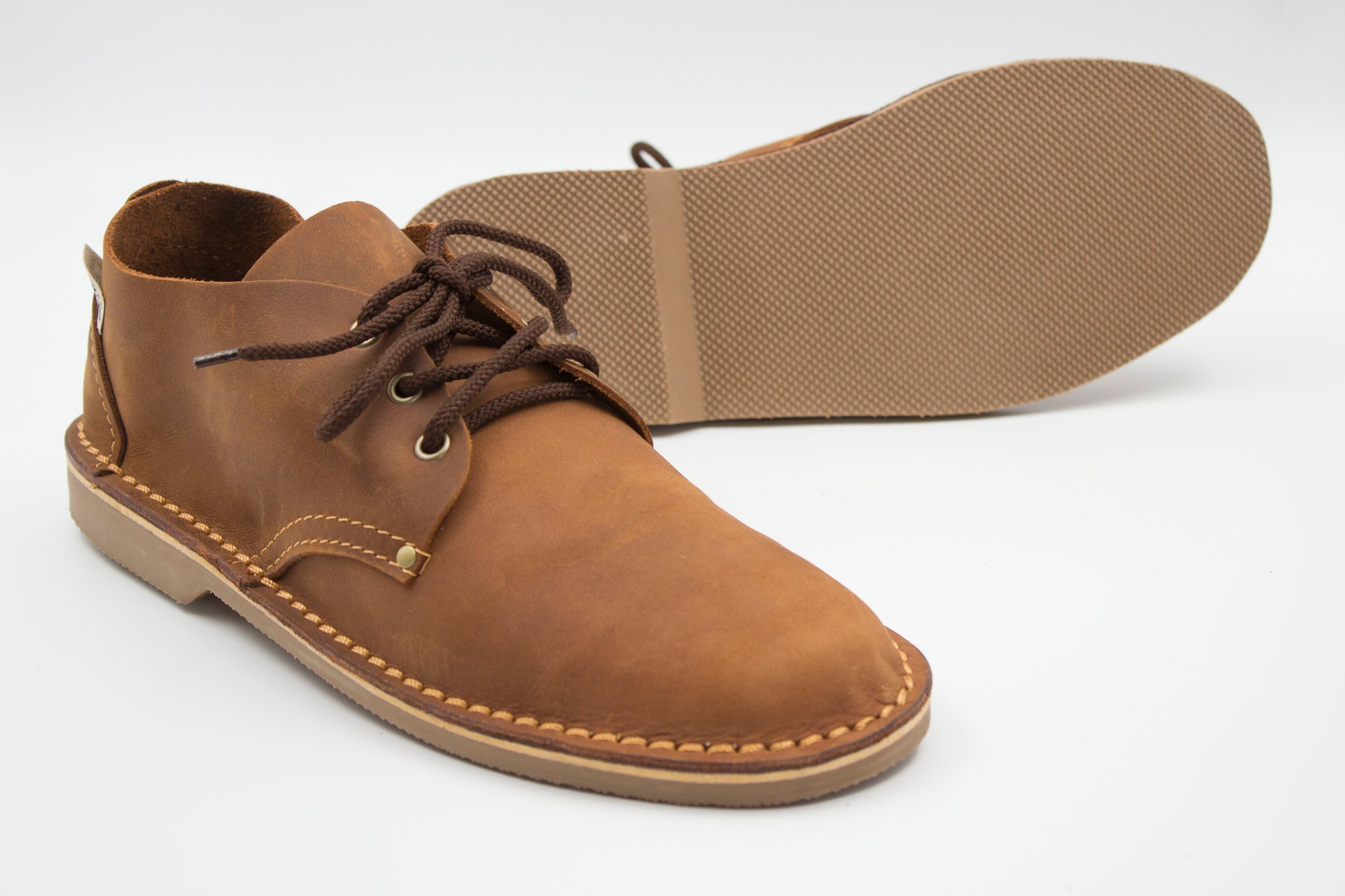 Low-cut veldskoen medium brown leather with durable muddy brown sole showing textured grip