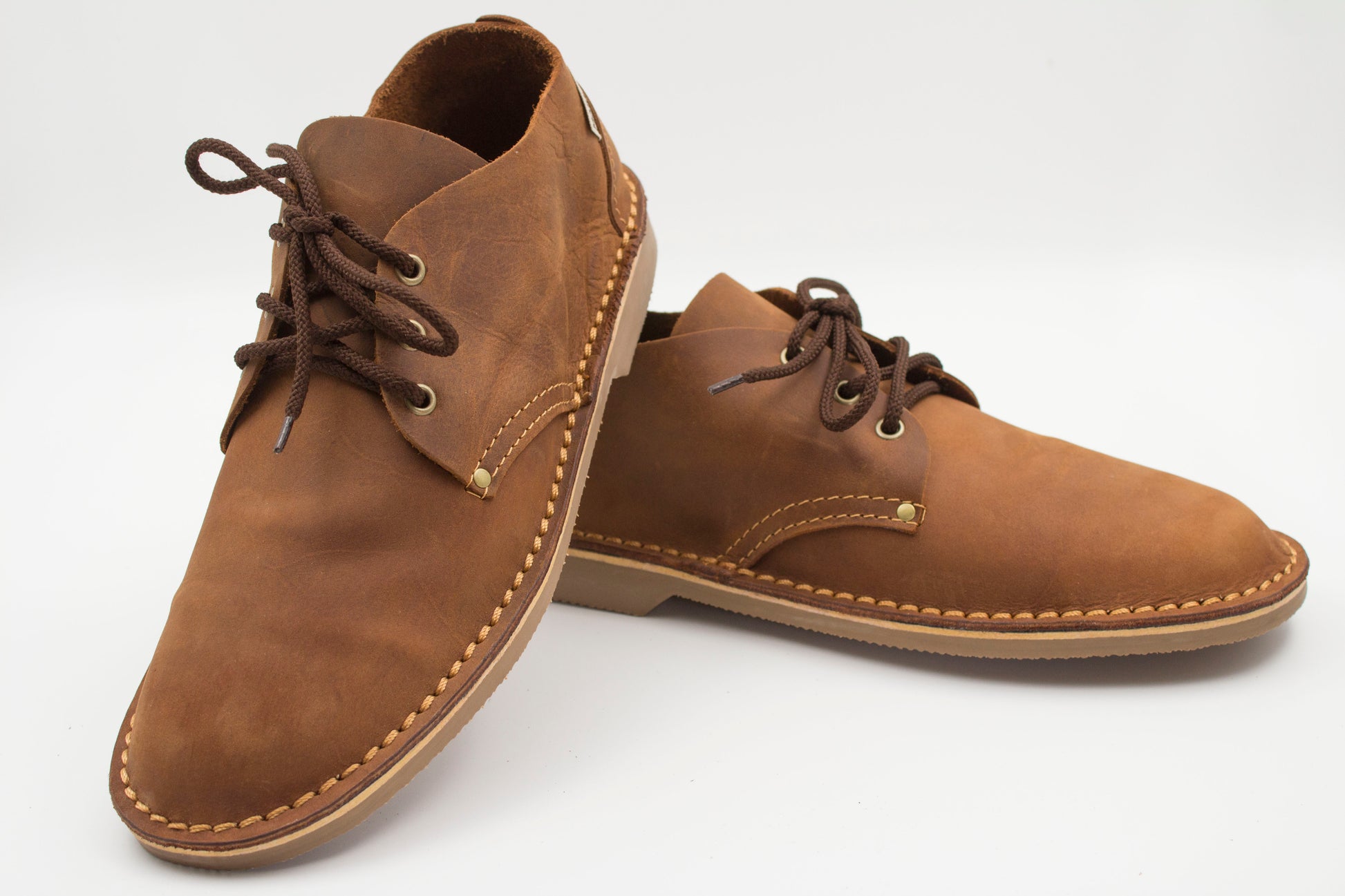Medium brown low-cut veldskoen pair showing full-grain leather and muddy brown sole detail